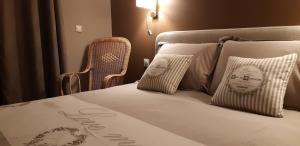 a bedroom with a bed with pillows and a chair at La Villanelle maison d'hôtes in Pelousey +90 photos