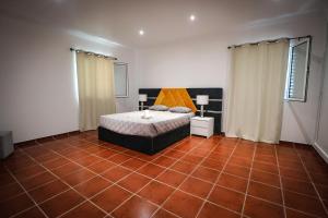 a bedroom with a bed and a tiled floor at Casa do Parque in Rabo de Peixe +10 photos
