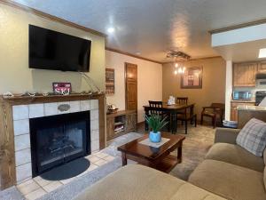 a living room with a fireplace with a flat screen tv at Snowed Inn in Brian Head