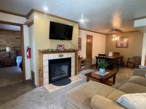 a living room with a fireplace with a tv above it at Snowed Inn in Brian Head