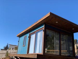 una piccola casa con una grande finestra in cima di Tiny cabaña en playa hermosa Pichilemu a Pichilemu