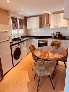 a kitchen with a wooden table with chairs and a table and a dining room at Les Fermes de Cal Panche Le Petit Relais in Les Angles
