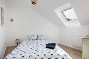 Un dormitorio con una cama en una habitación blanca. en Appartement Le Cap Morgat, en Crozon