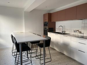 a kitchen with a table and some black chairs at La villa Alixel in Pléneuf-Val-André +9 photos