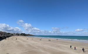 a group of people on a beach near the ocean at La villa Alixel in Pléneuf-Val-André