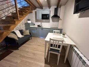 ラス・アレーナス・デ・カブラレスにあるApartamentos San Roqueのテーブルと椅子のあるキッチンとリビングルーム