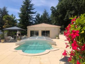 ein Swimmingpool in einem Hof mit einem Haus in der Unterkunft Les oiseaux du paradis in Saint-Antoine-de-Breuilh