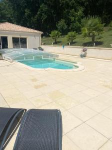 einen Pool in der Mitte einer Terrasse in der Unterkunft Les oiseaux du paradis in Saint-Antoine-de-Breuilh