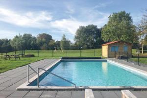 a large swimming pool in a yard with a house at Stinswoning Noorderlicht in Tzummarum
