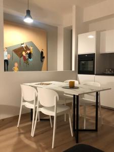 a dining room with a table and chairs and a painting at Verde Acqua Suite in Lecco +20 photos