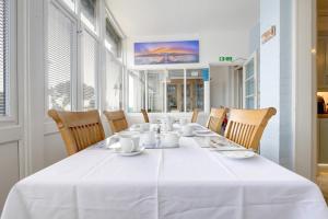 a white table with chairs and a white table cloth at Bay Lodge Guest House in Eastbourne