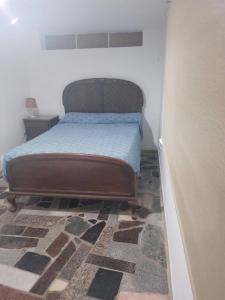 ein Schlafzimmer mit einem Bett in einem Zimmer mit einem Teppich in der Unterkunft casa de descanso el molino 2 in Cordoba