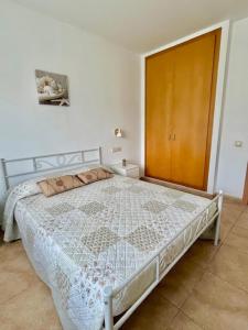 a bedroom with a white bed with a wooden door at Nature House in Maçanet de la Selva +40 photos