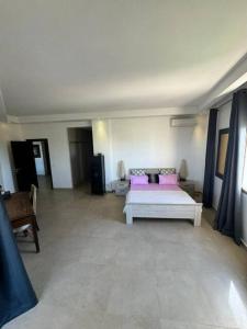 Una habitación con una cama con almohadas rosas. en King's Lair, Embassy Ocean View Apartment, Dakar, Senegal, en Dakar