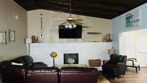 a living room with leather furniture and a fireplace at Ocean Pearl Villa in Oak Island
