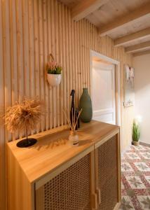 a wooden cabinet with plants on it in a room at La Maison de la Plage in Le Grau-du-Roi