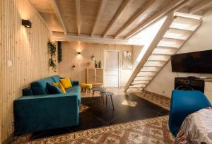 a living room with a blue couch and a tv at La Maison de la Plage in Le Grau-du-Roi