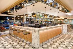 a bar in a restaurant with chairs and a counter at Crowne Plaza Manchester Airport by IHG in Manchester Airport