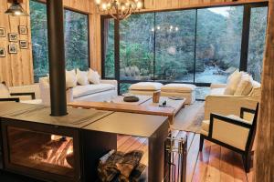 a living room with a fireplace in a house at Lodge El Remanso, Patagonia Chile in Llanada Grande