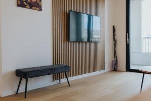 a room with a stool and a tv on a wall at New Design Apt Bratislava - DownTown & Parking in Bratislava