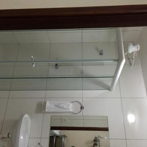 La salle de bains est pourvue d'un lavabo, de toilettes et d'un miroir. dans l'établissement Pousada Verdes Flores, à Brasilia