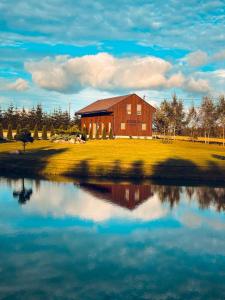 a barn sitting next to a body of water at Sodyba "Bičiuliai" in Plungė +44 photos