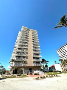 a tall building with palm trees in front of it at #903 Panoramic Ocean View at Lovers Key Beach Club in Fort Myers Beach