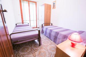 um quarto com 2 camas e uma mesa com um candeeiro em Gemma 3 Pineto Vacanza em Pineto