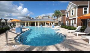 a swimming pool with two chairs and a house at Magic Villa Orlando in Orlando