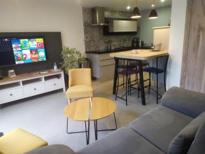 Una sala de estar con un sofá y una cocina. en La Loge Bertine France, en Saint-Mars-la-Réorthe