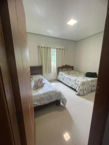 a bedroom with two beds and a window at Casa Goulart in Capitólio