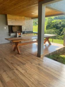 a large wooden table on a patio with a grill at Casa Goulart in Capitólio