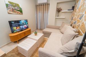a living room with a couch and a flat screen tv at Ioannina Center Apartment in Ioannina