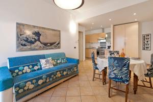 a living room with a blue couch and a table at Domus 21 Near Alassio Beach - Happy Rentals in Alassio