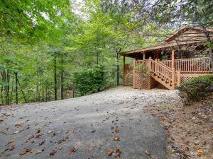 une grande maison avec une grande terrasse dans les bois dans l'établissement 1BR log cabin- cozy, hot tub, in Gatlinburg, à Gatlinburg