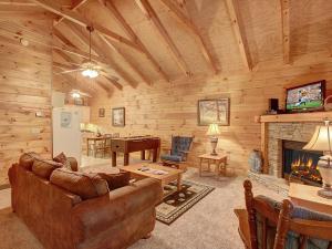 un salon avec un canapé et une cheminée dans l'établissement 1BR log cabin- cozy, hot tub, in Gatlinburg, à Gatlinburg