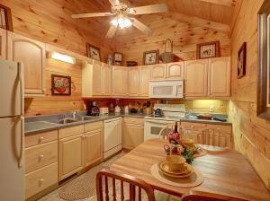 une cuisine avec des placards en bois, une table en bois et un plafond dans l'établissement 1BR log cabin- cozy, hot tub, in Gatlinburg, à Gatlinburg