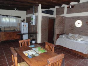 a bedroom with a bed and a table and a kitchen at Cabañas los amigos Tala in Potrero de Garay