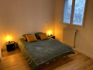 a bedroom with a bed with two lamps on it at l 'Escapade Atlantique in Saint-Nazaire