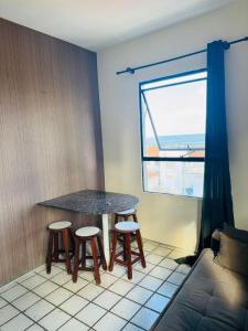 einen Tisch und Stühle in einem Zimmer mit Fenster in der Unterkunft Full Apartment in Recife