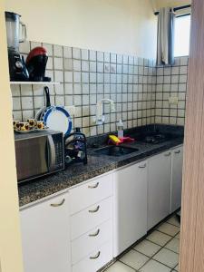 eine Küche mit Spüle und Mikrowelle in der Unterkunft Full Apartment in Recife