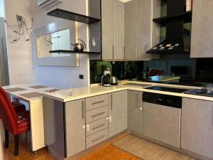 a kitchen with gray cabinets and a red chair at Residenza Il Carducci in Bergamo