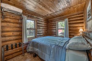 una camera con un letto in una baita di tronchi di Edgewater Resort a Iron Mountain