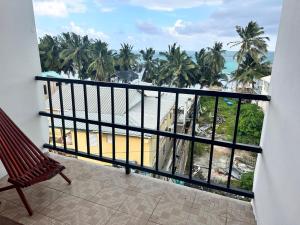 キー・カーカーにあるEnjoy Hotelのビーチとヤシの木の景色を望むバルコニー