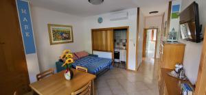 Casetta Pineta Mare في بورتو سان جورجيو: غرفة معيشة بسرير ازرق وطاولة