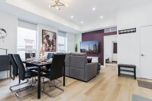 トロントにあるNew Elegant Suite for 8 w Patio - Heart of Torontoのテーブルと椅子のあるダイニングルームとリビングルーム