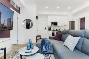 トロントにあるNew Elegant Suite for 8 w Patio - Heart of Torontoのソファとテーブルのあるリビングルーム