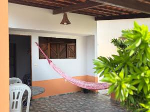 a hammock in the front of a house at Chalé Estrela do mar in Galinhos
