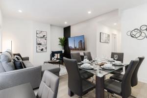 a dining room and living room with a table and chairs at Casa Hotels McCaul - New with Workspace & Kitchen in Toronto