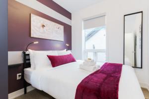 トロントにあるModern Suite 3 min to Transit Downtown Torontoのベッドルーム1室(紫色をアクセントにした白い大型ベッド1台付)